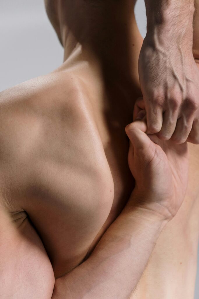 Close-up of a man's muscular back and arms in a yoga stretch, showcasing flexibility and fitness.